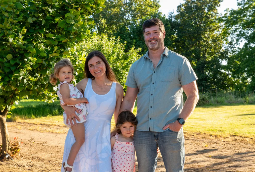 Family standing in hazelnut trees